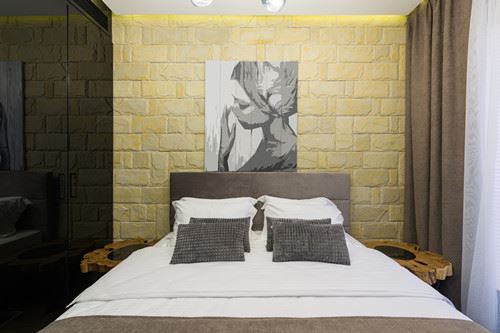 Canva - Bedroom interior with painting on brick wall in hotel Canva - Bedroom interior with painting on brick wall in hotel
